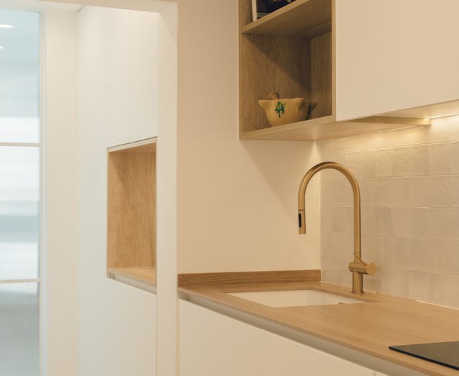 Detalle de cocina reformada en maderas y tonos claros por Proyecta Lara